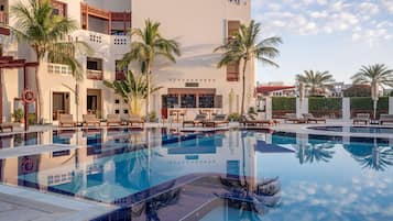 Una piscina al aire libre, sombrillas, tumbonas