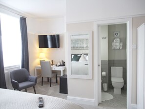 A hotel room with a bed, a desk, a chair, a TV, a bathroom with a toilet and sink. - Elmdon Lodge (Birmingham)