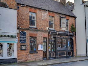 A traditional brick building with a black facade, featuring a sign for 'George & Dragon Inn' and a smaller sign for 'The G&D Bed & Breakfast' with guest rooms and a restaurant/bar.