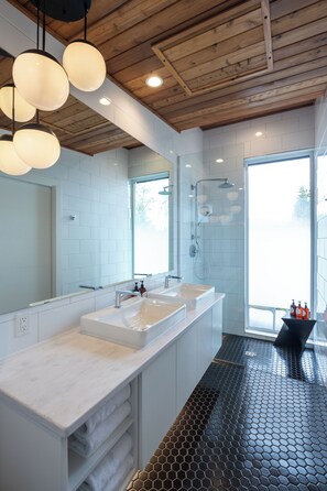 A modern bathroom with a wooden ceiling, two sinks, a large mirror, and a shower area. - Duffin Cove Oceanfront Lodging (Tofino)