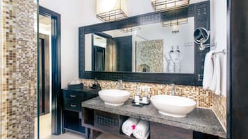 Un baño moderno con dos lavamanos, un espejo grande y un perchero para toallas.