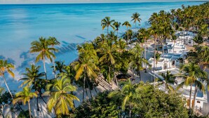 A beach resort with palm trees, white buildings, and a view of the ocean. - Diamonds Mapenzi Beach (Kiwengwa)