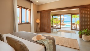 A bedroom with a large bed, a view of the ocean, and a balcony with outdoor furniture. - Diamonds Mapenzi Beach (Kiwengwa)