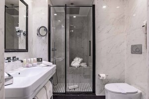 Un bagno moderno con doccia vetrata, un lavandino bianco e un water.