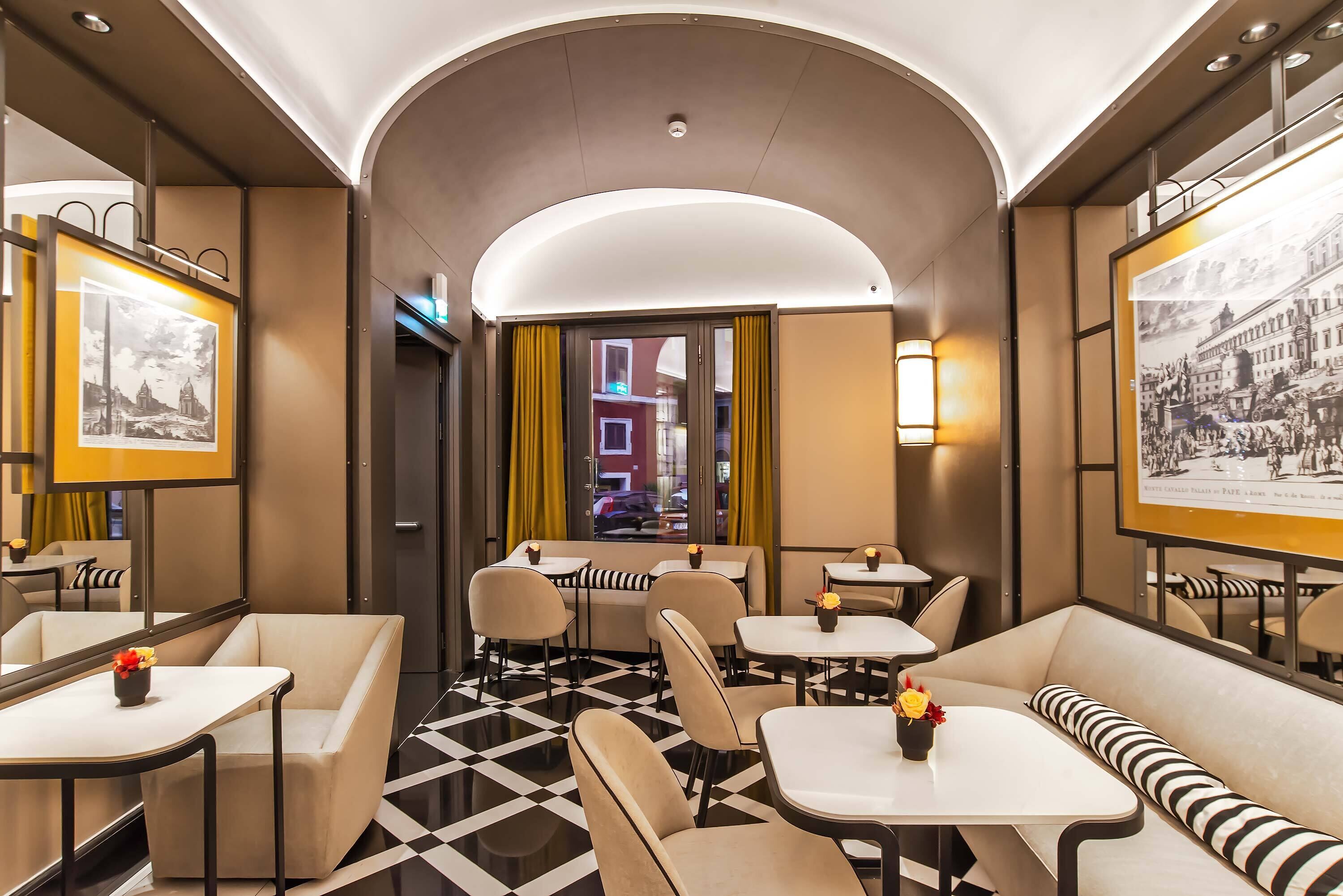 A modern interior with a checkered floor, seating arrangements, and framed pictures on the walls.