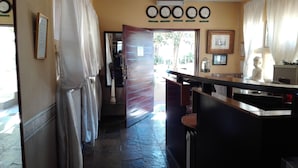 A hotel lobby with a reception desk, a clock, and a Buddha statue.