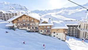 Ein Skigebiet mit Holzhäusern, Skipisten und einem Sessellift.