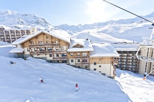 A ski resort with wooden buildings, ski slopes, and a chairlift.