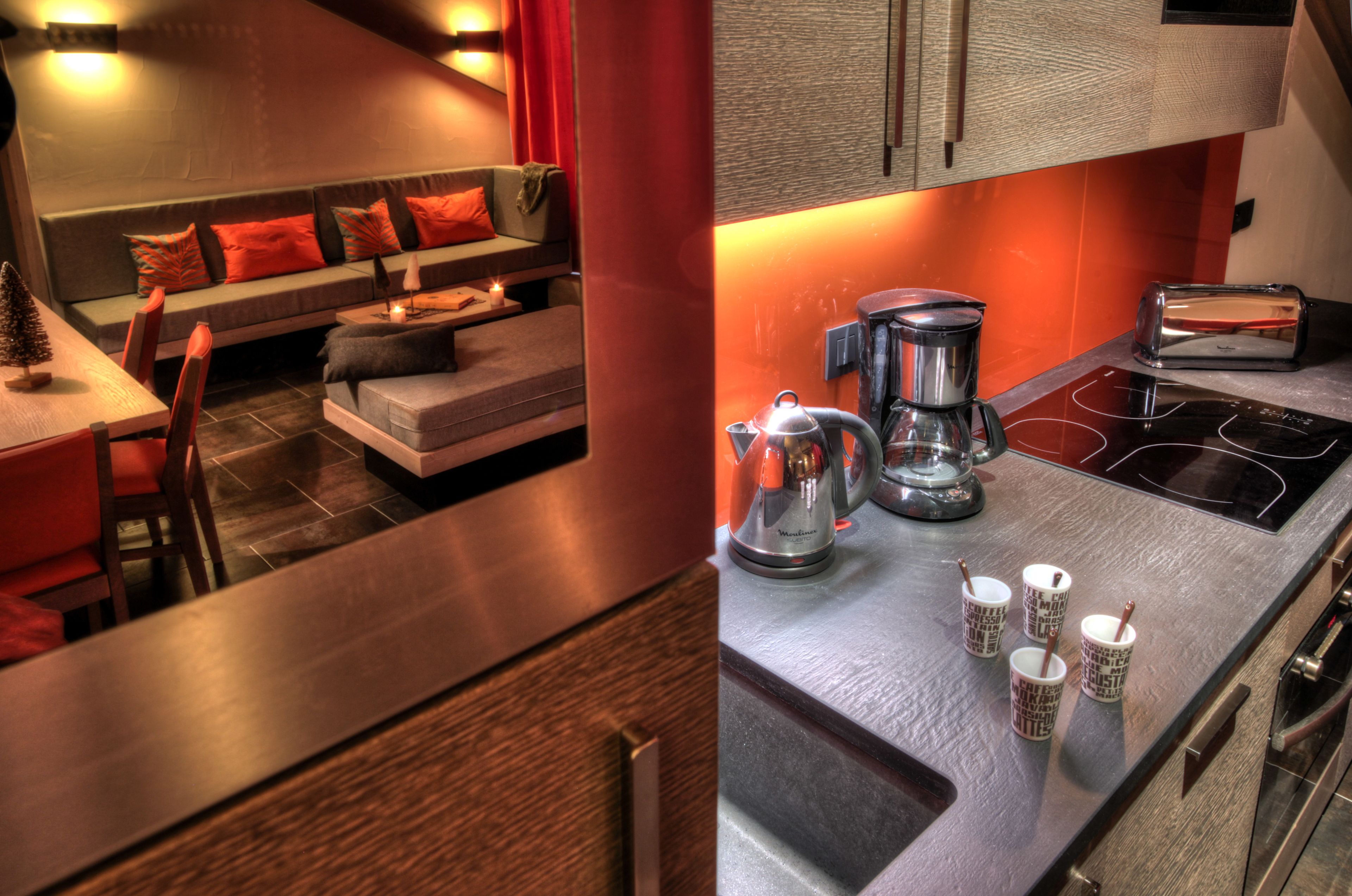 A modern kitchen with a gas stove, coffee maker, and toaster.