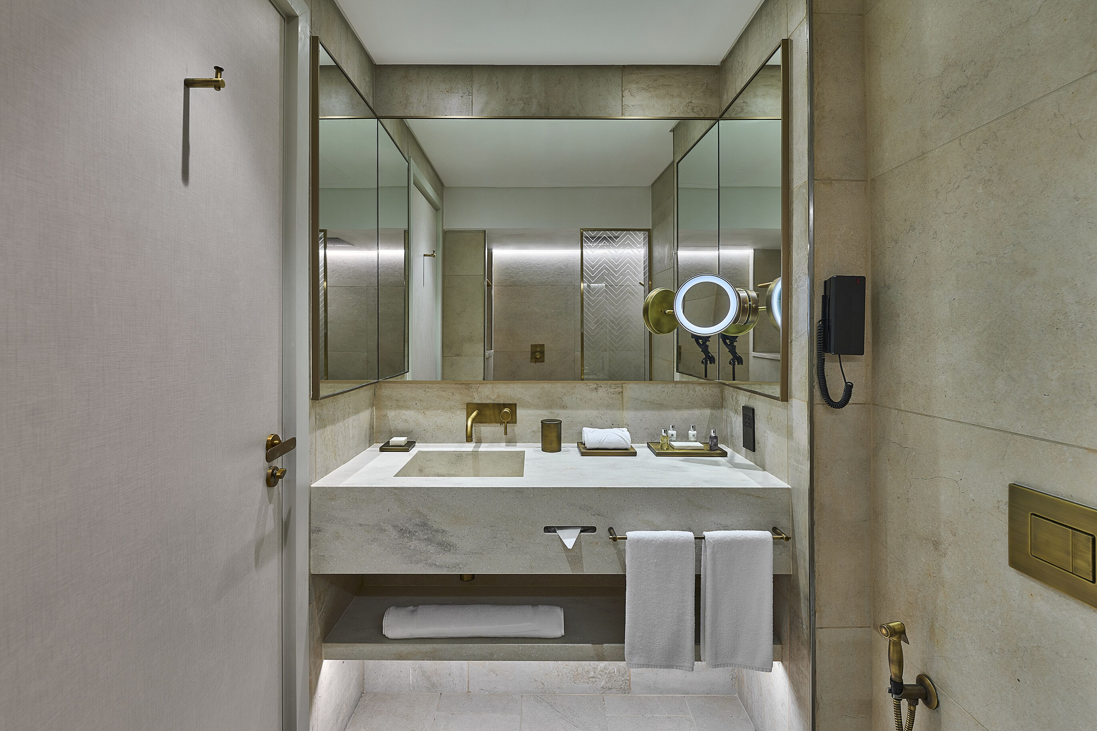 A modern bathroom with a large mirror, a sink, and a bathtub.
