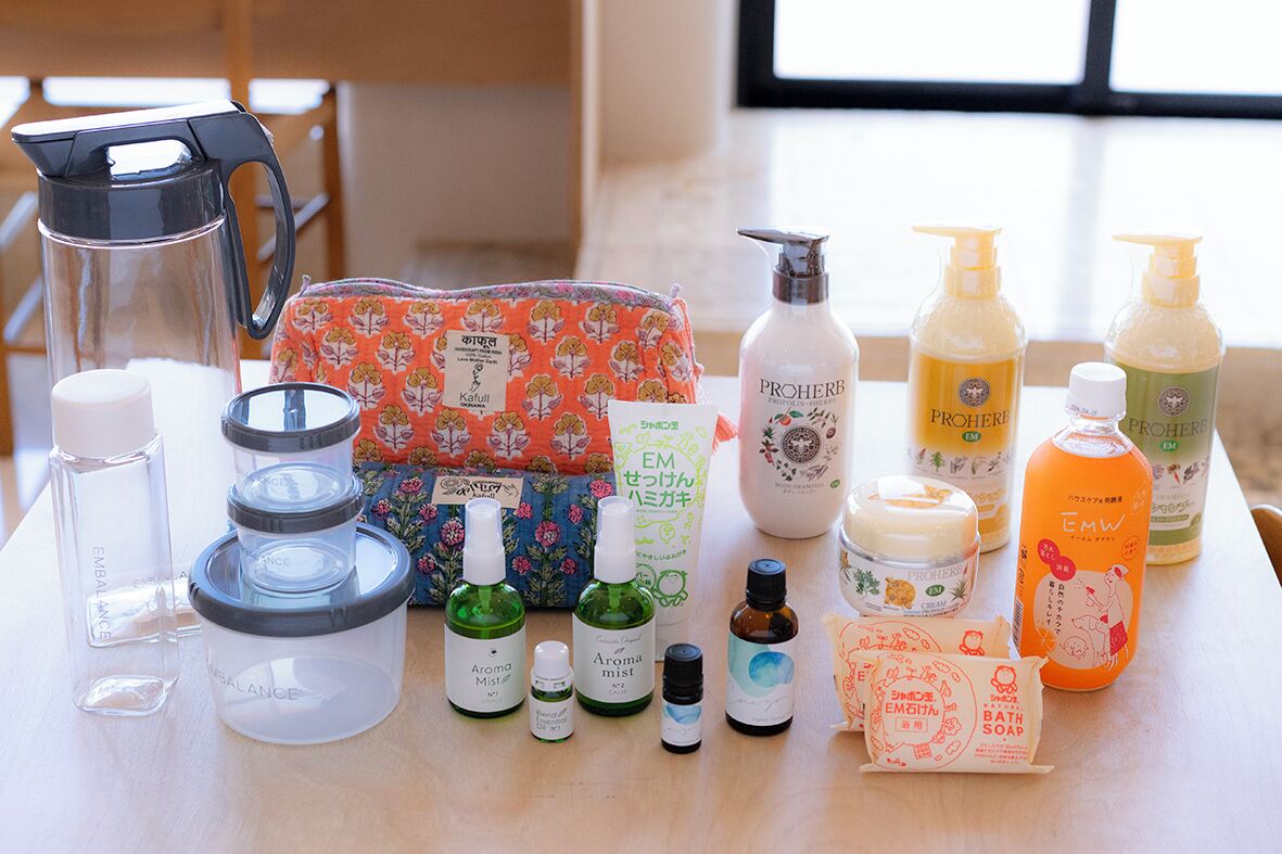 Une variété de produits de soins personnels est disposée sur une table, notamment des flacons de parfum, du savon pour le bain et d’autres articles de toilette.