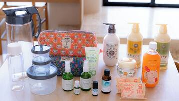 Une variété de produits de soins personnels est disposée sur une table, notamment des flacons de parfum, du savon pour le bain et d’autres articles de toilette.