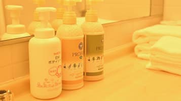 A bathroom with multiple bottles of hair care products on the counter.