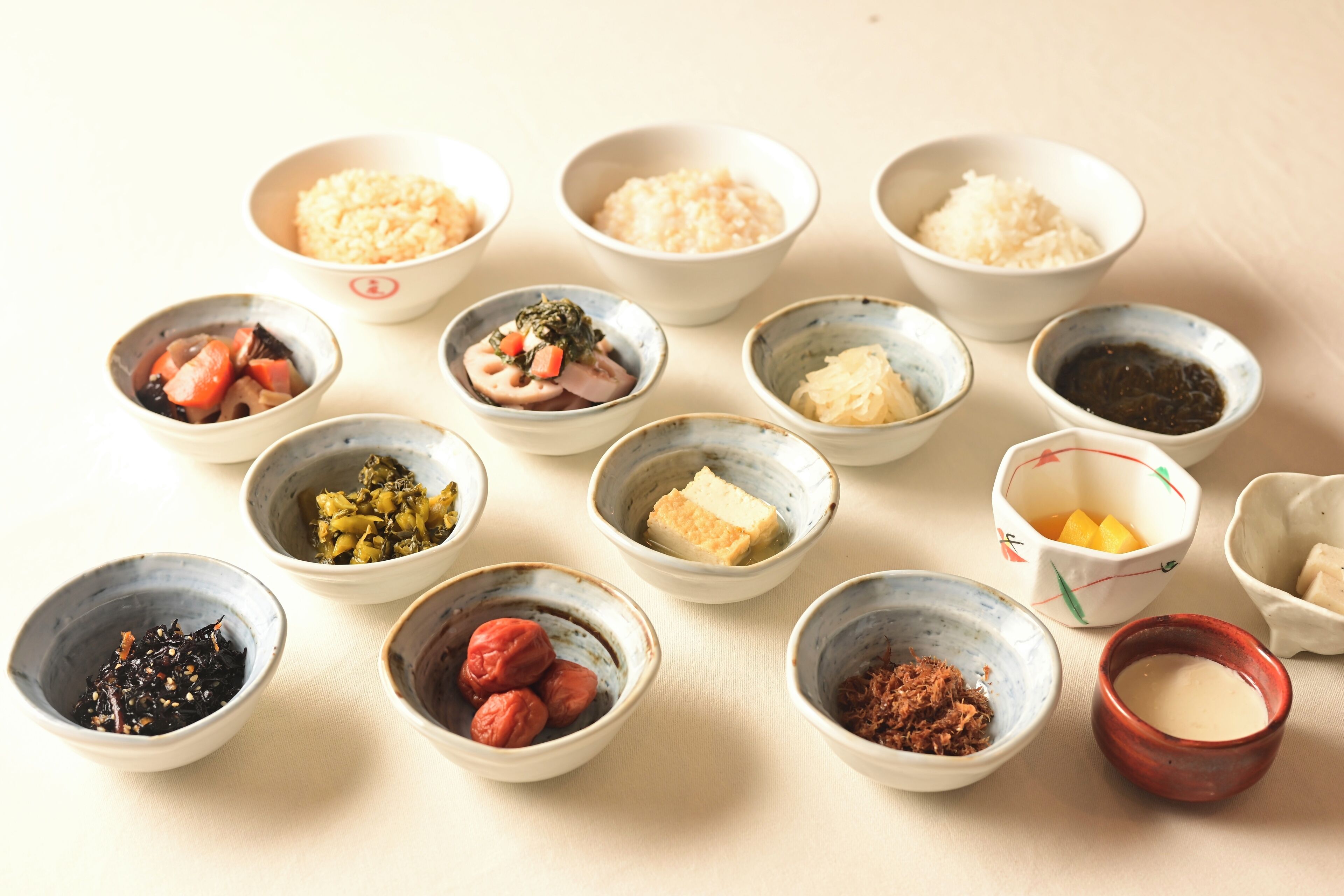 A variety of small bowls containing different food items, likely part of a Japanese meal.