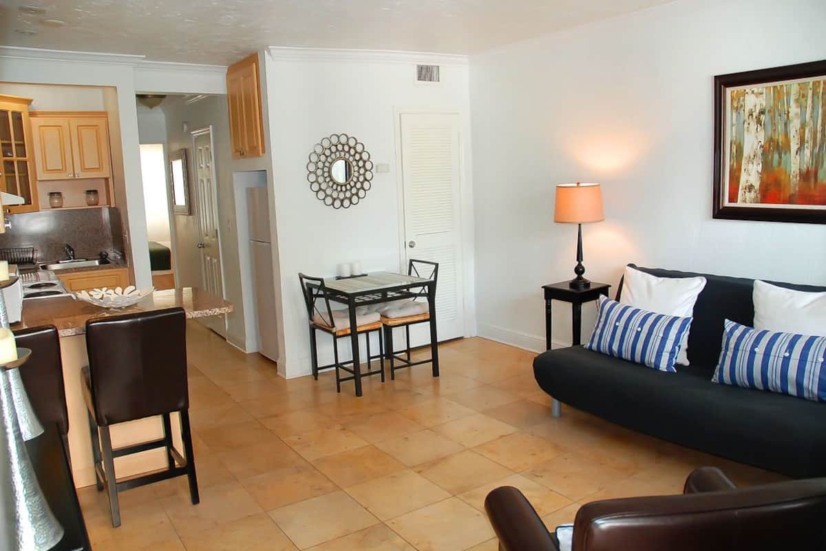 A compact living space with a dining area, a sofa, and a kitchen.