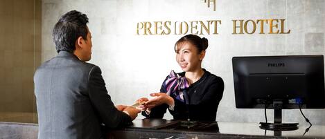 A reception desk at the President Hotel with a marble counter and a Philips monitor.