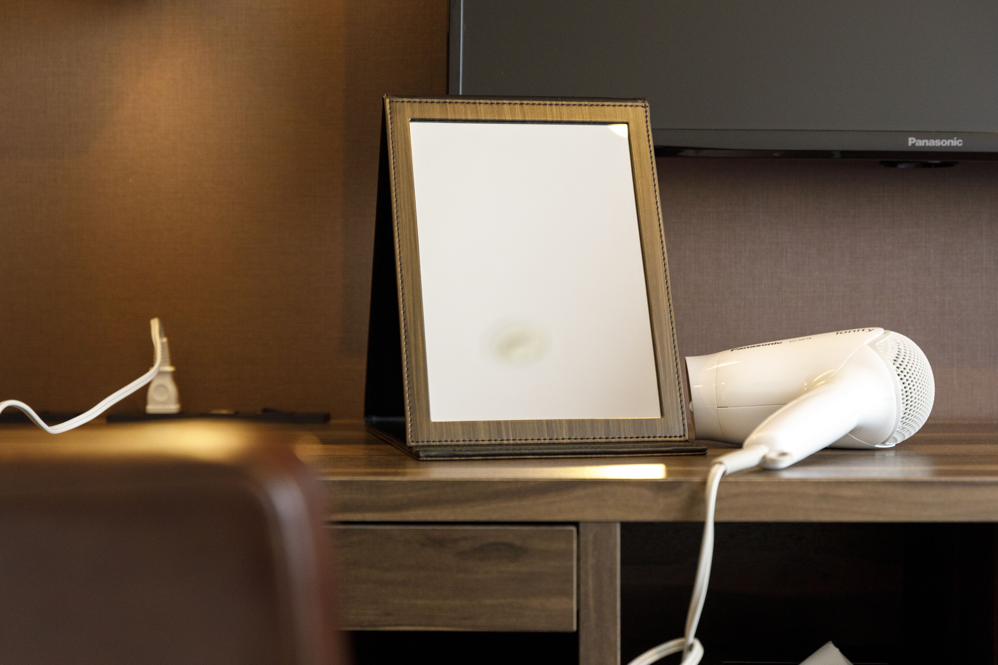 Quadro emoldurado sobre uma mesa, com um secador de cabelo e um cabo de alimentação.