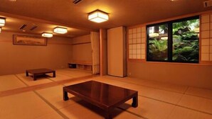 Una habitación japonesa tradicional con suelo de tatami, una mesa de madera baja y puertas correderas.