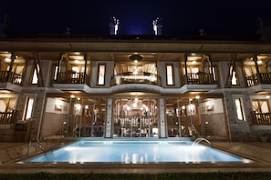 A large, multi-story hotel with a swimming pool in the foreground. - Kerme Ottoman Konak - Boutique Class (Ula)