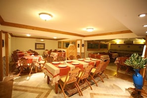 A dining area with multiple tables and chairs, a patterned floor, and a ceiling with recessed lighting. - Kerme Ottoman Konak - Boutique Class (Ula)