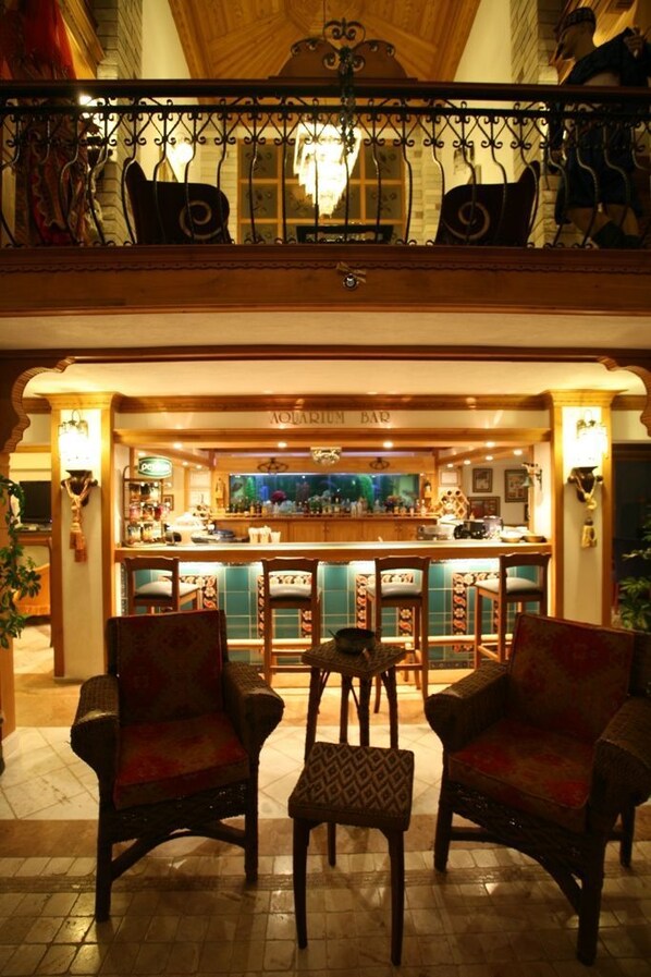 Zona de bar con muebles de madera y una barra.