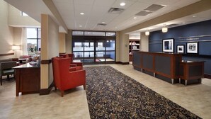 A lobby with a reception desk, seating area, and a patterned carpet. - Hampton Inn & Suites Charles Town (Charles Town)