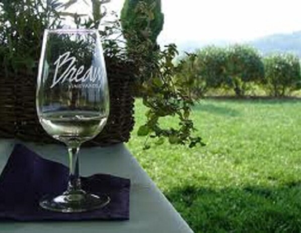 A wine glass with the inscription "Vineyard" on a table set outdoors with a grassy background and a basket. - Hampton Inn & Suites Charles Town (Charles Town)