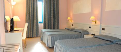Une chambre d’hôtel avec deux lits, un bureau avec une chaise, une télévision et deux lampes de chevet.