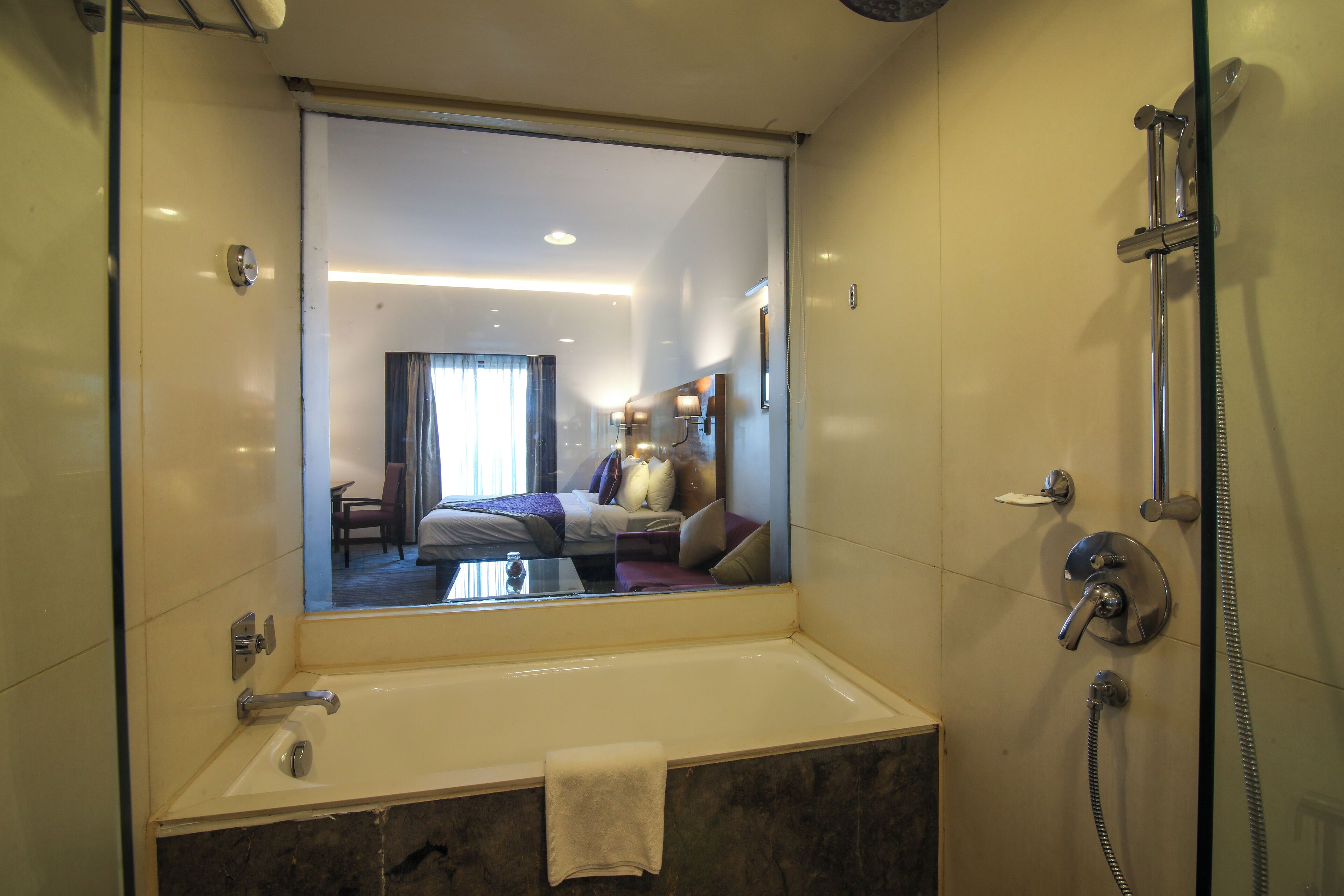 A modern bathroom with a large mirror, a bathtub, and a shower.