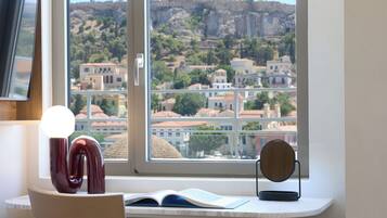 A study area with a desk, chair, and a view of a cityscape through a window.