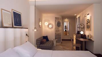 Habitación de hotel moderna con una cama grande, un escritorio con una silla, un sofá y una mesita. Hay cuadros enmarcados en la pared, un espejo y una lámpara decorativa.