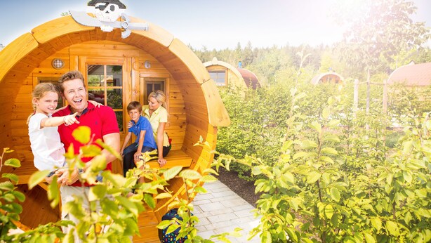 Une cabane en bois, ornée d’une décoration sur le toit évoquant le thème des pirates, et entourée d’une végétation luxuriante.