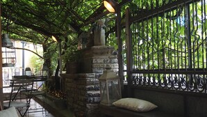 A stone-built structure with a lantern, surrounded by greenery and a wrought iron fence. - Hotel San Giuseppe (Cernobbio)