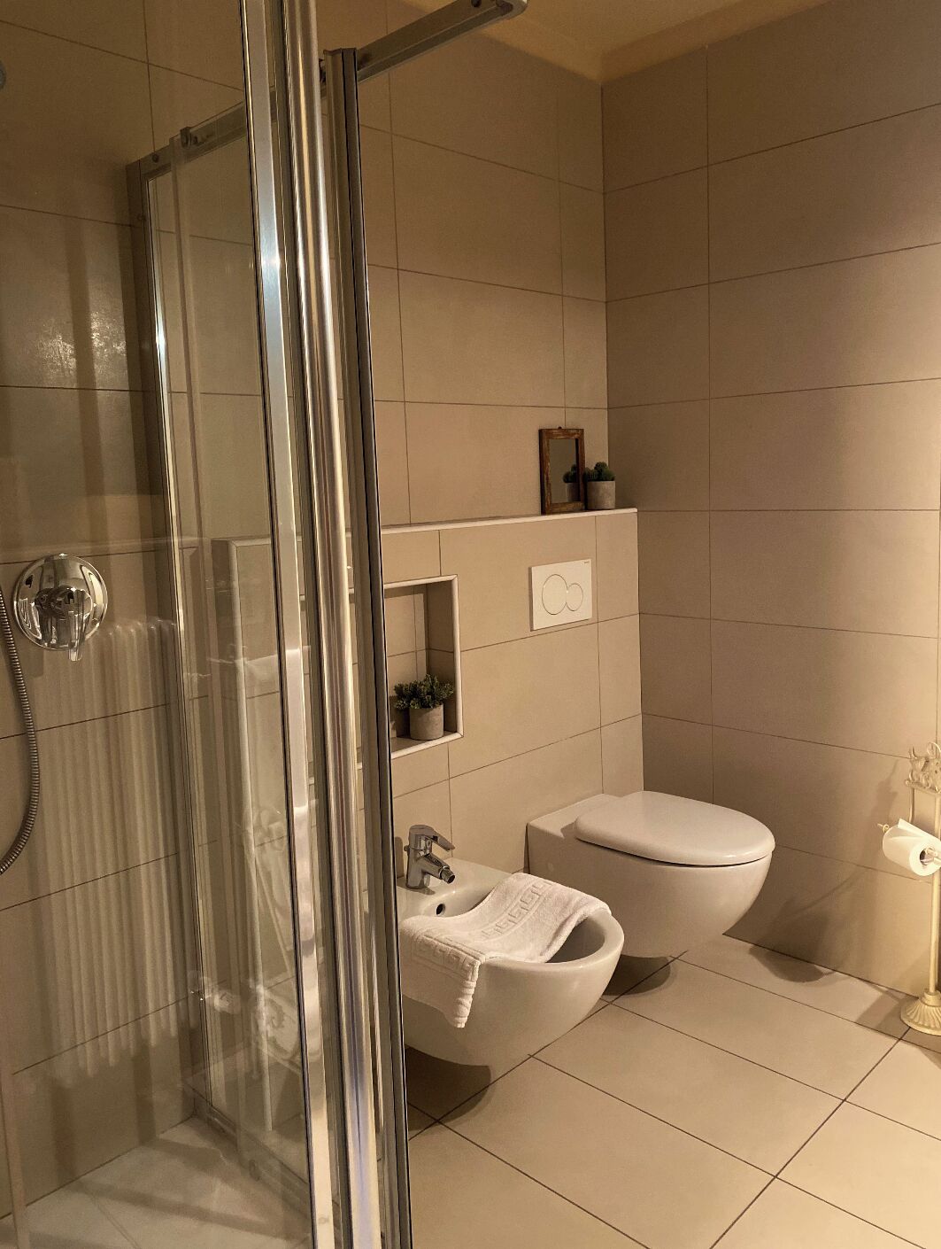 A modern bathroom with a glass shower enclosure, a white sink, and a toilet.
