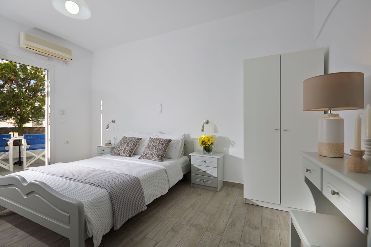 Un dormitorio con cama, mesitas de noche, armario y ventana con vistas.
