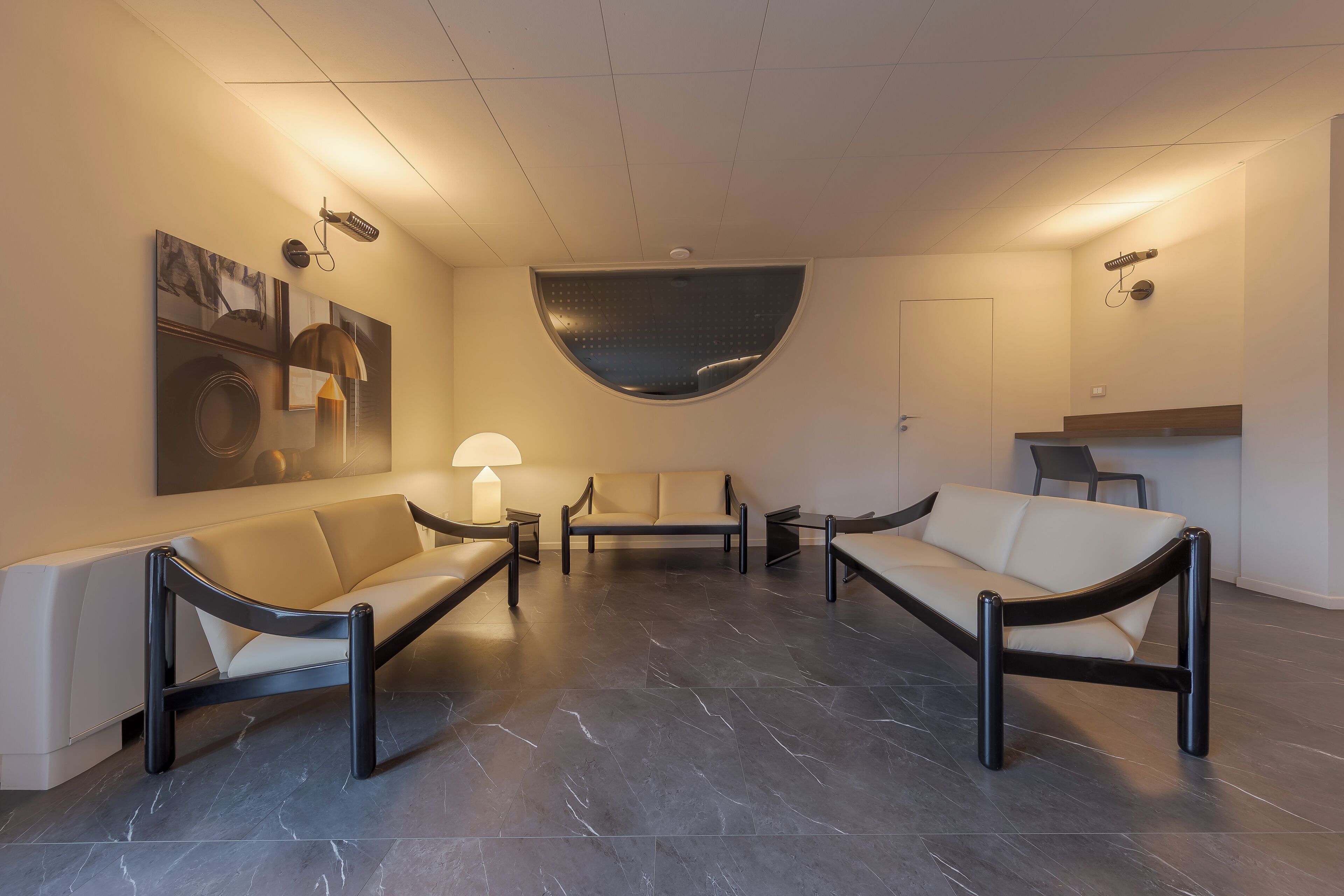 Un hall d’entrée moderne avec un canapé, une table basse et une lampe.