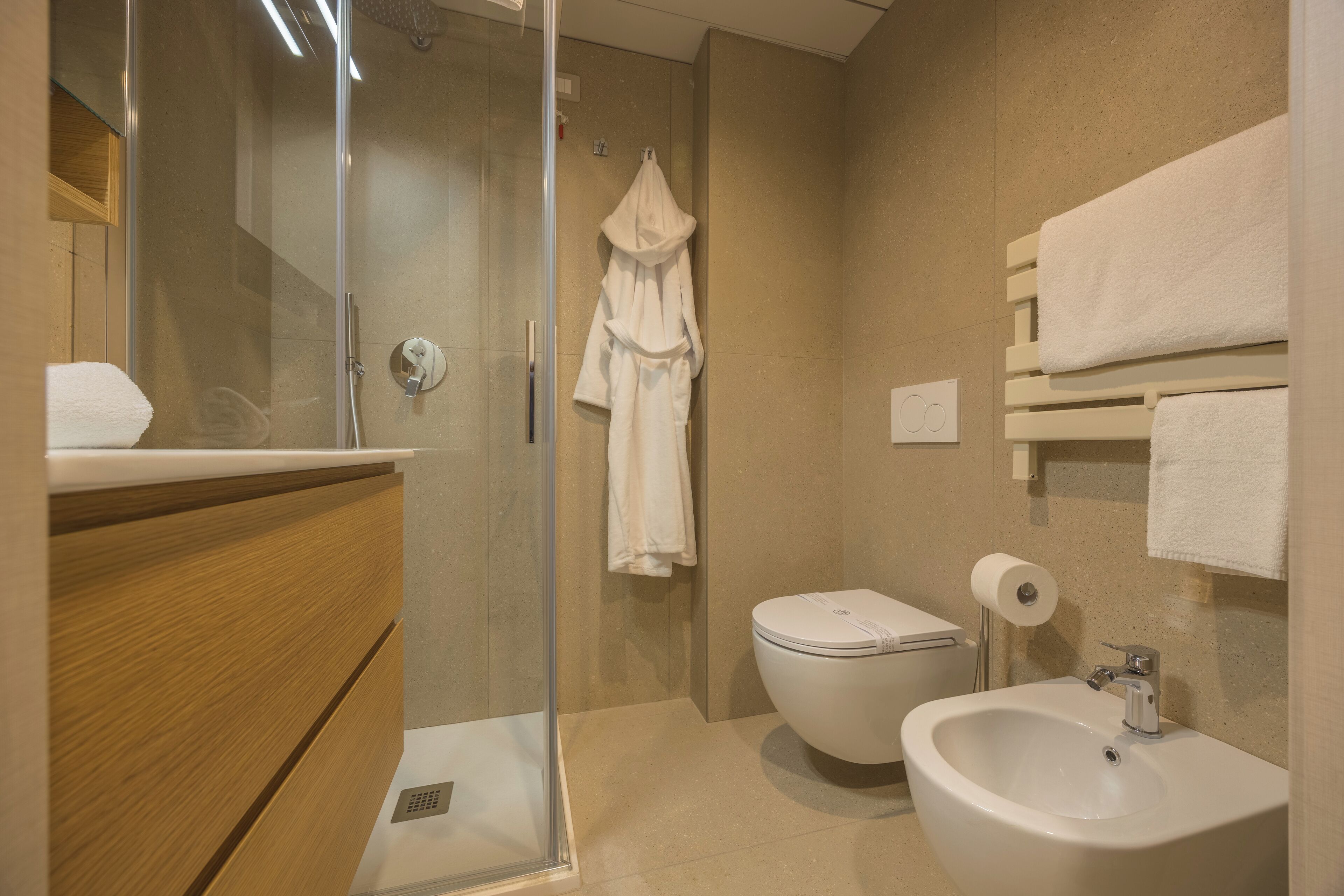 Un baño moderno con cabina de ducha de vidrio, inodoro y lavamanos.