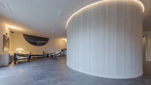 A modern lobby with a curved wall, seating area, and a reception desk. - Centro Siloe Residence Hotel (Milan)
