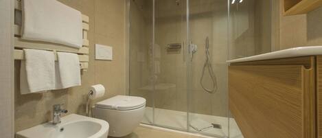 Une salle de bain moderne avec une douche à parois de verre, un bidet, des toilettes et un lavabo.