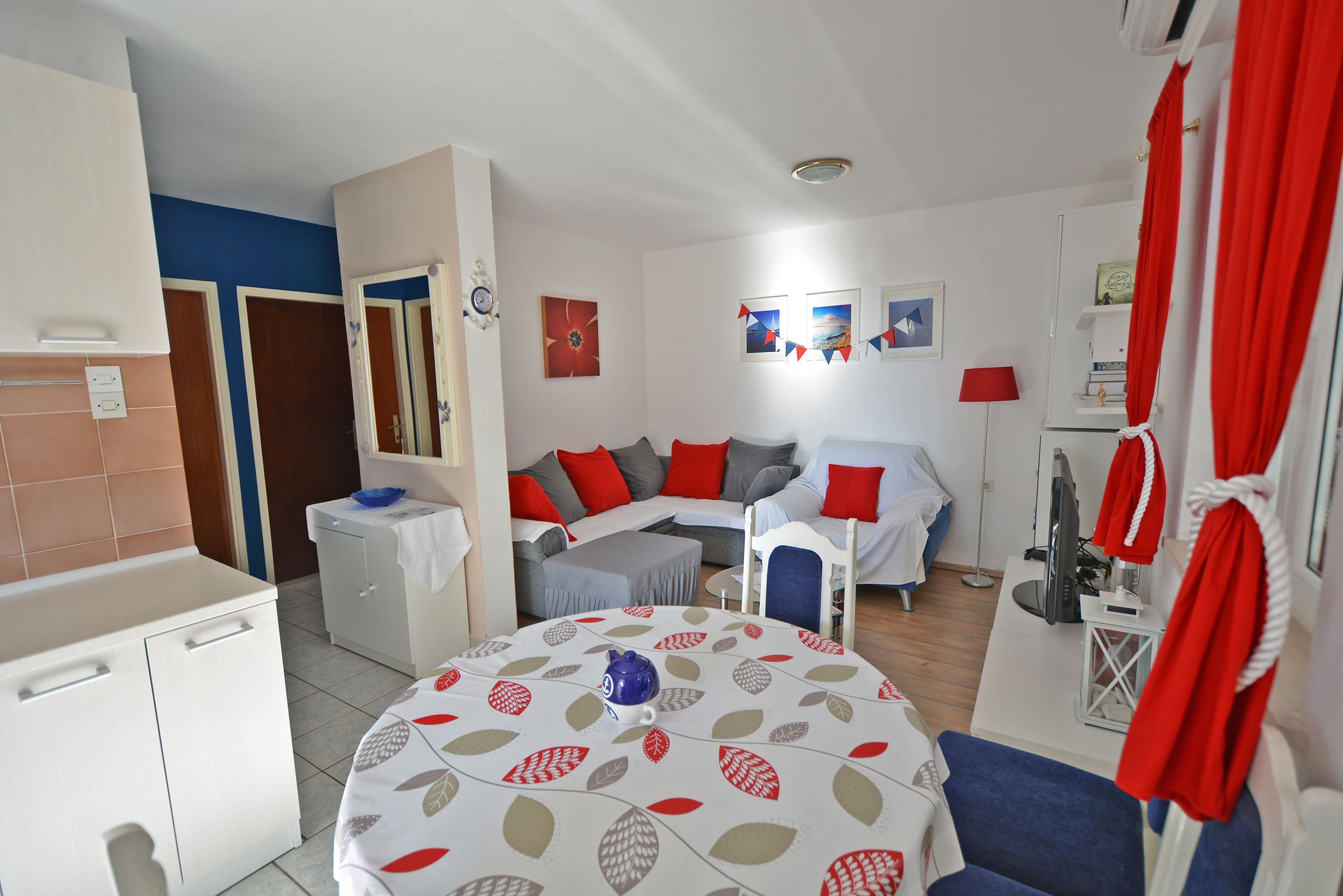 A compact living space with a kitchenette, a dining area, and a seating area with a sofa and chairs.