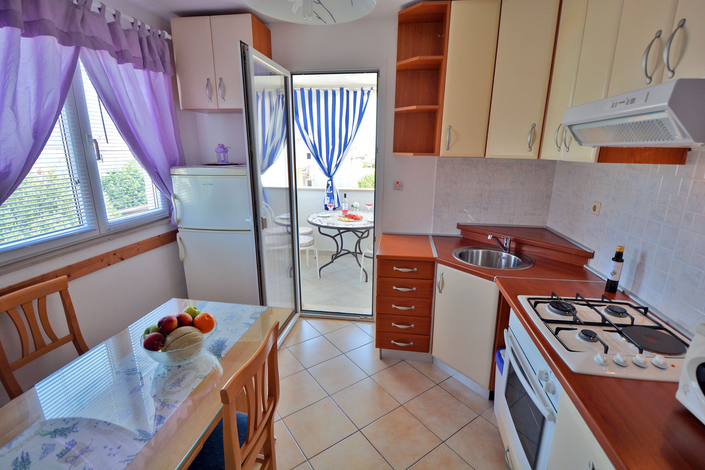 A compact kitchen with a dining table, a refrigerator, a stove, and a sink.