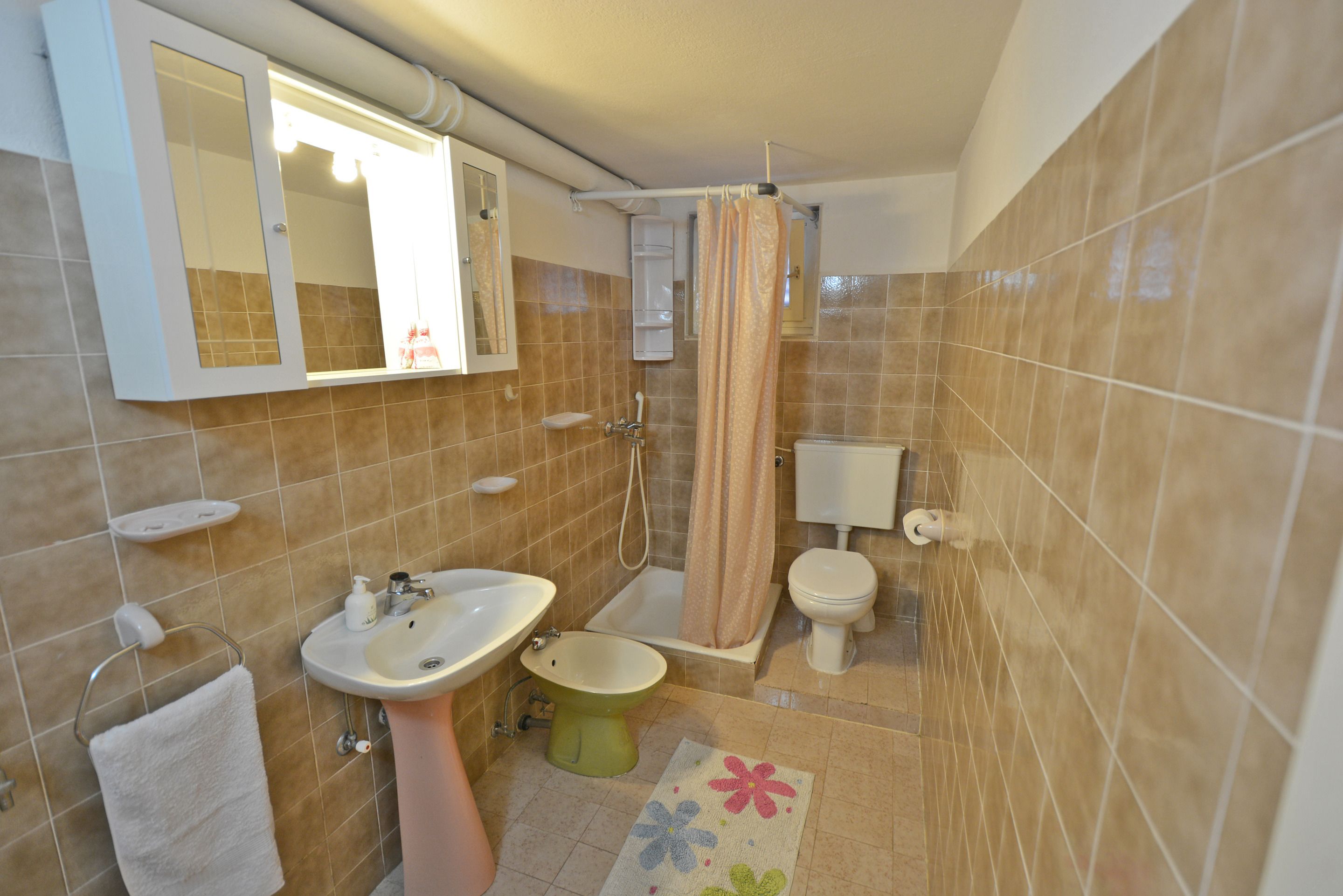 A bathroom with a sink, toilet, bathtub, and a mirror.