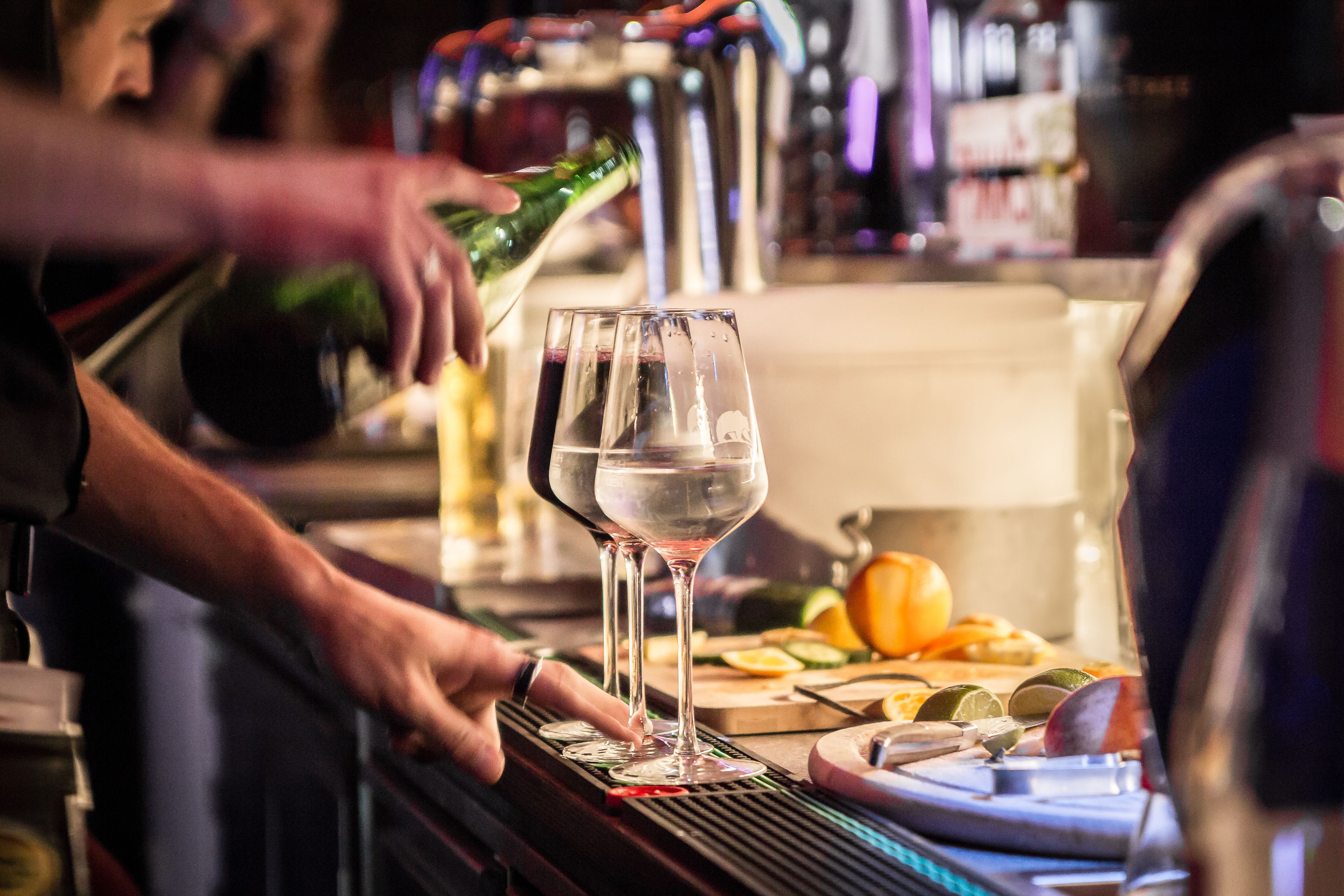 Ein Barkeeper gießt ein Getränk ein.
