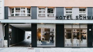 The exterior of Hotel Schwarzer Bar with large glass windows and a modern facade. - Hotel Schwarzer Bär (Linz)