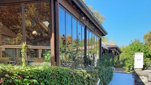 Un bâtiment moderne doté de grandes fenêtres et d’une enseigne indiquant qu’il s’agit d’un hôtel, d’un restaurant et d’un bar.