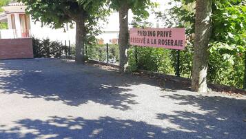 A parking area with a sign indicating reserved parking for the rose garden.