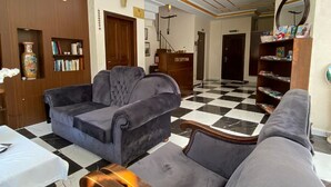 A hotel lobby with a checkered floor, a reception desk, and a seating area with sofas. - Villa Sofia (Istanbul)