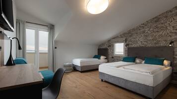 Habitación triple, balcón, vista al mar | Caja de seguridad en la habitación, escritorio y cortinas blackout