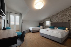 Una habitación de hotel moderna con dos camas, un escritorio y vista a la ciudad.