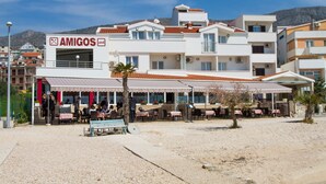 Un bâtiment sur lequel on peut lire l’inscription « AMIGOS », et qui dispose d’une terrasse avec des tables et des chaises.